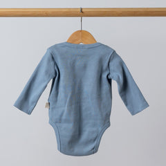 Back view of cute baby blue long sleeve bodysuit in thick jersey rib cotton hanging on wooden rail