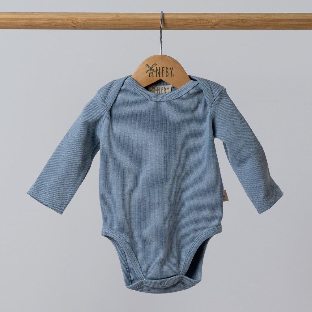 Blue body suit with small Aneby hem tag on the side, hanging from rail