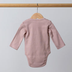 Back view of long sleeve baby bodysuit on wooden rail