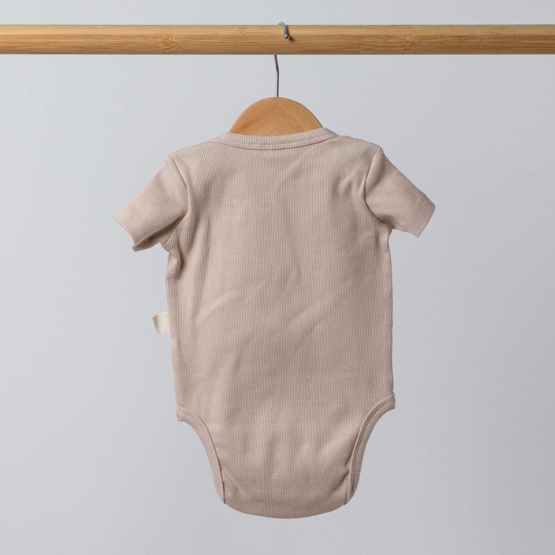 Back view of short sleeve ecru bodysuit vest on wooden clothes hanger