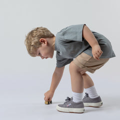 Young boy wearing beige Aneby shorts with elasticated waistband and rolled hem