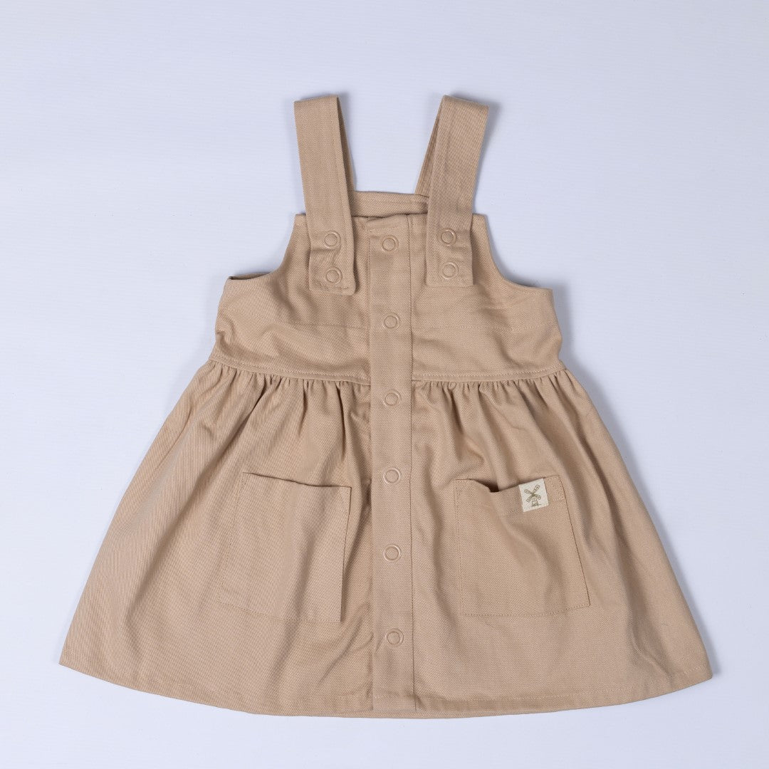 Oat coloured dress with shoulder straps, patch pocket and Aneby windmill hem tag