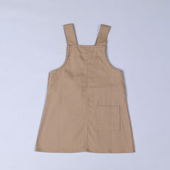 Rear view of oat beige dungaree dress with patch pocket and centre back seam