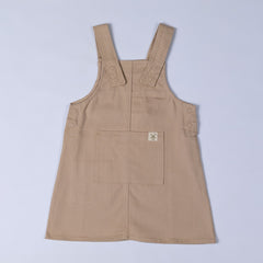 Beige dungaree dress with dyed to match poppers and front pocket featuring the Aneby hem tag