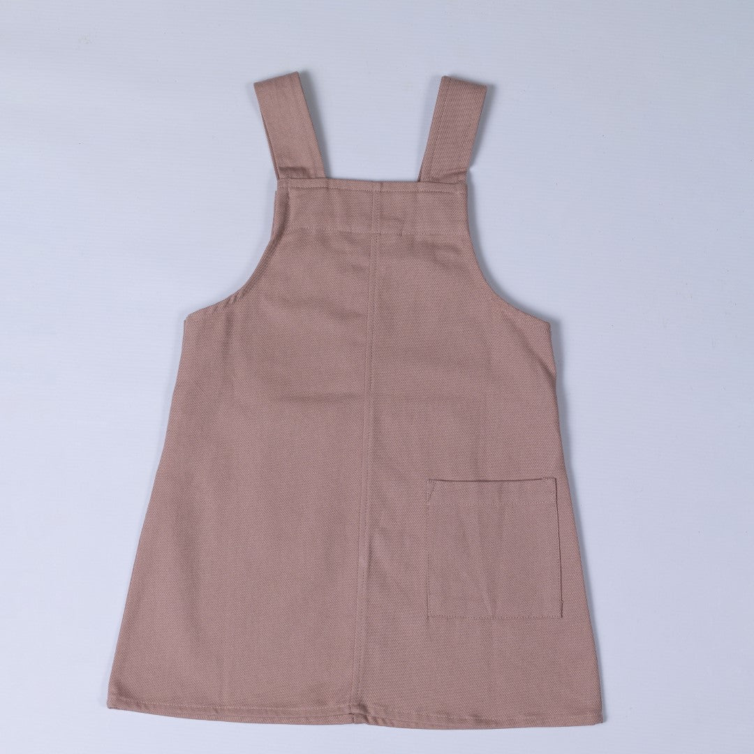 Rear view of dusty pink dungaree dress with patch pocket and centre back seam