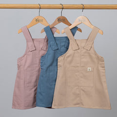 Matching dungaree dresses in pink, blue and beige on Aneby hangers