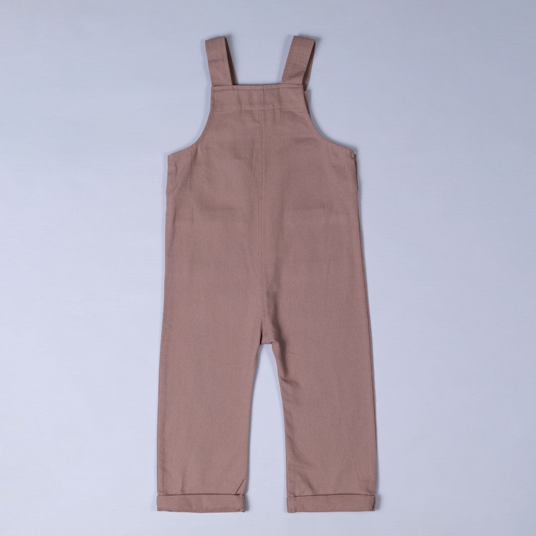 Rear view of dusty pink dungarees with shoulder straps and rolled hem