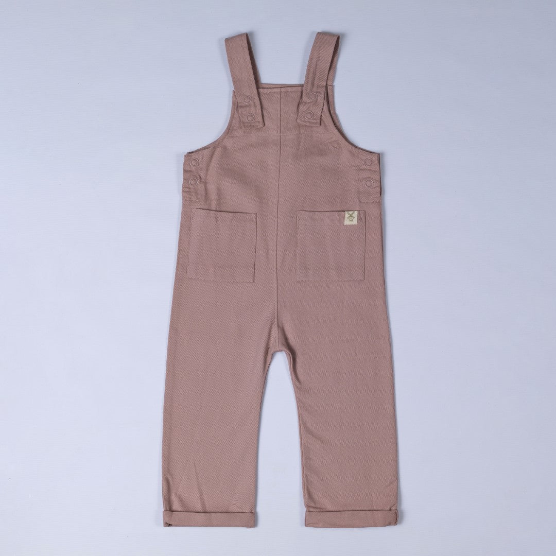 Dusty pink dungarees with shoulder straps, patch pockets, dyed to match poppers and rolled hem