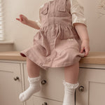 Girl Sitting Down Wearing Pink Button Front Twill Dress