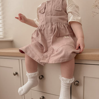 Girl Sitting Down Wearing Pink Button Front Twill Dress