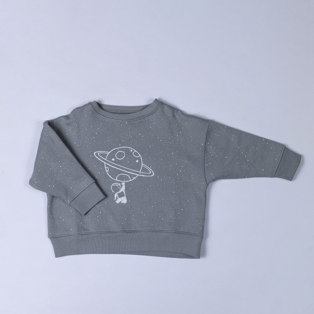 Product image of grey jumper featuring astronaut hanging onto planet ring