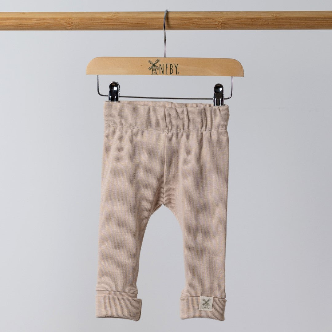 Beige baby leggings on wooden hanger