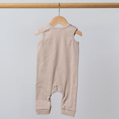 Rear view of oat baby romper on wooden hanger