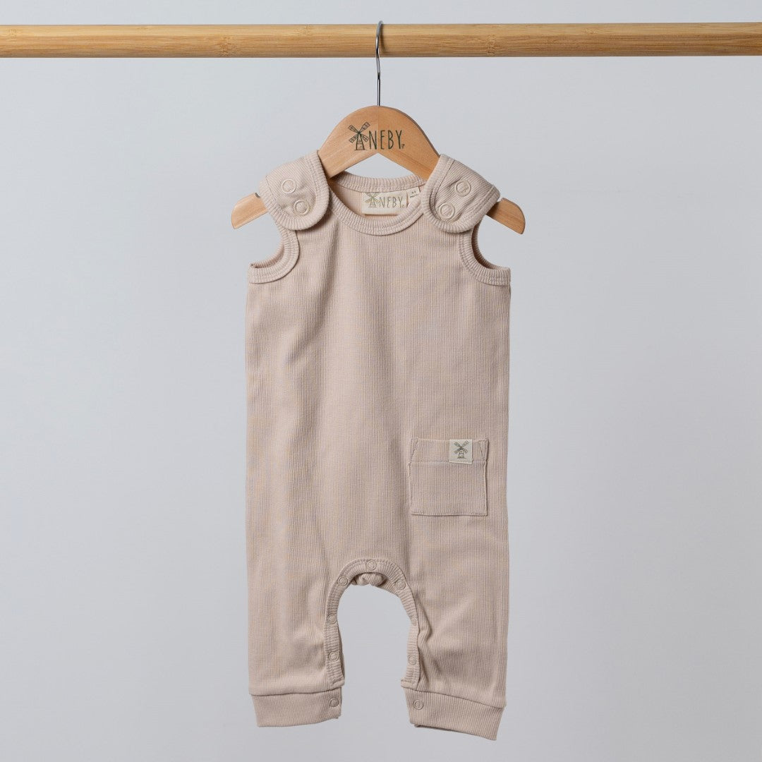 Beige baby romper hanging from wooden hanger with dyed to match poppers