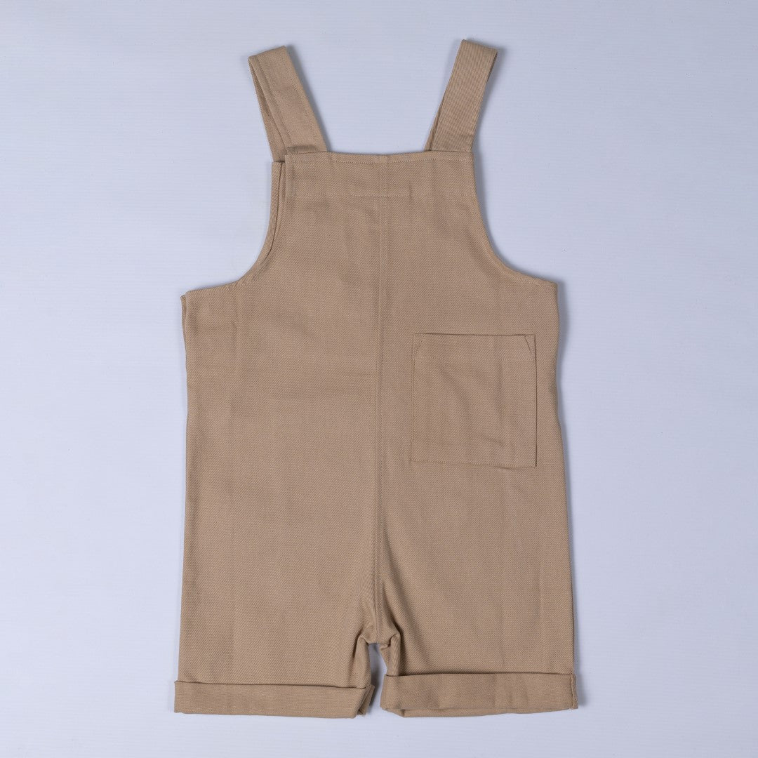 Back of oat beige Aneby dungaree shorts with shoulder straps and square patch pocket on back right leg