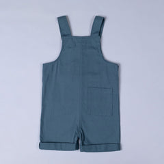 Back of steel blue Aneby dungaree shorts with shoulder straps and square patch pocket on back right leg