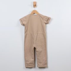 Back of Oat beige jumpsuit with patch pocket and rolled hem