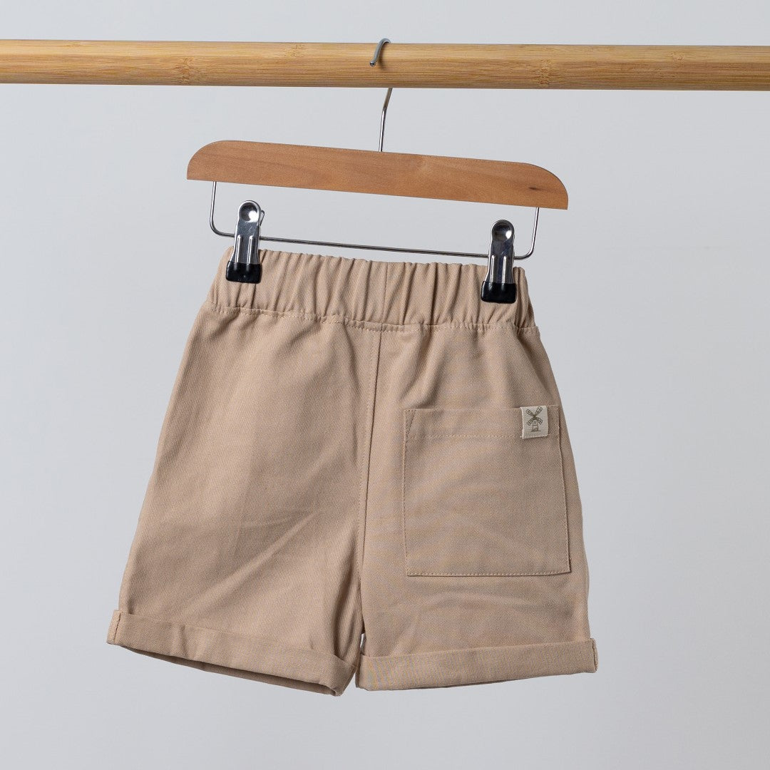 Rear view of oat Aneby shorts on wooden hanger with rolled hem and elasticated waist band