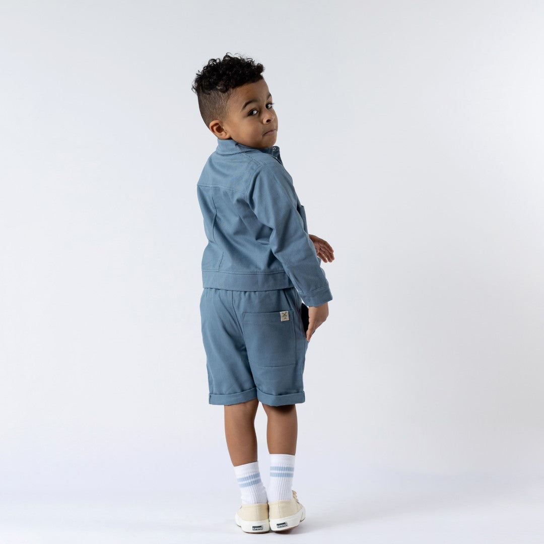 Back view of blue boxy jacket and matching twill shorts