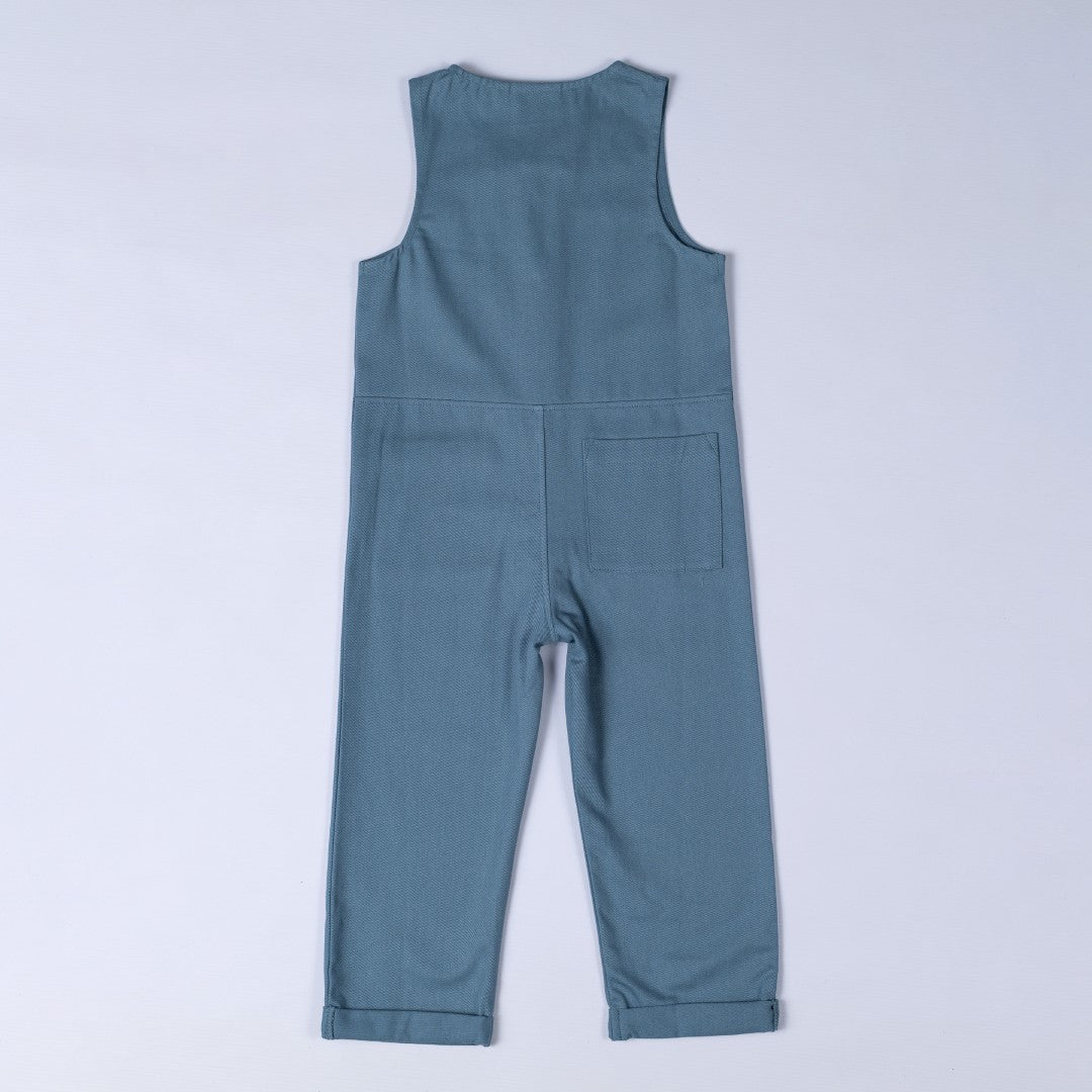 Rear view of twill sleeveless jumpsuit in petrol blue with waist seam and square patch pocket