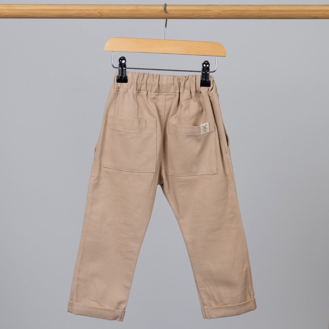 Neutral coloured chinos on a wooden clothes hanger with hem-tag in view