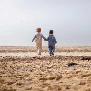 Aneby models holding hands walking towards the sea 