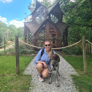 Stephanie, the founder of Aneby crouching down with her dog Dexter