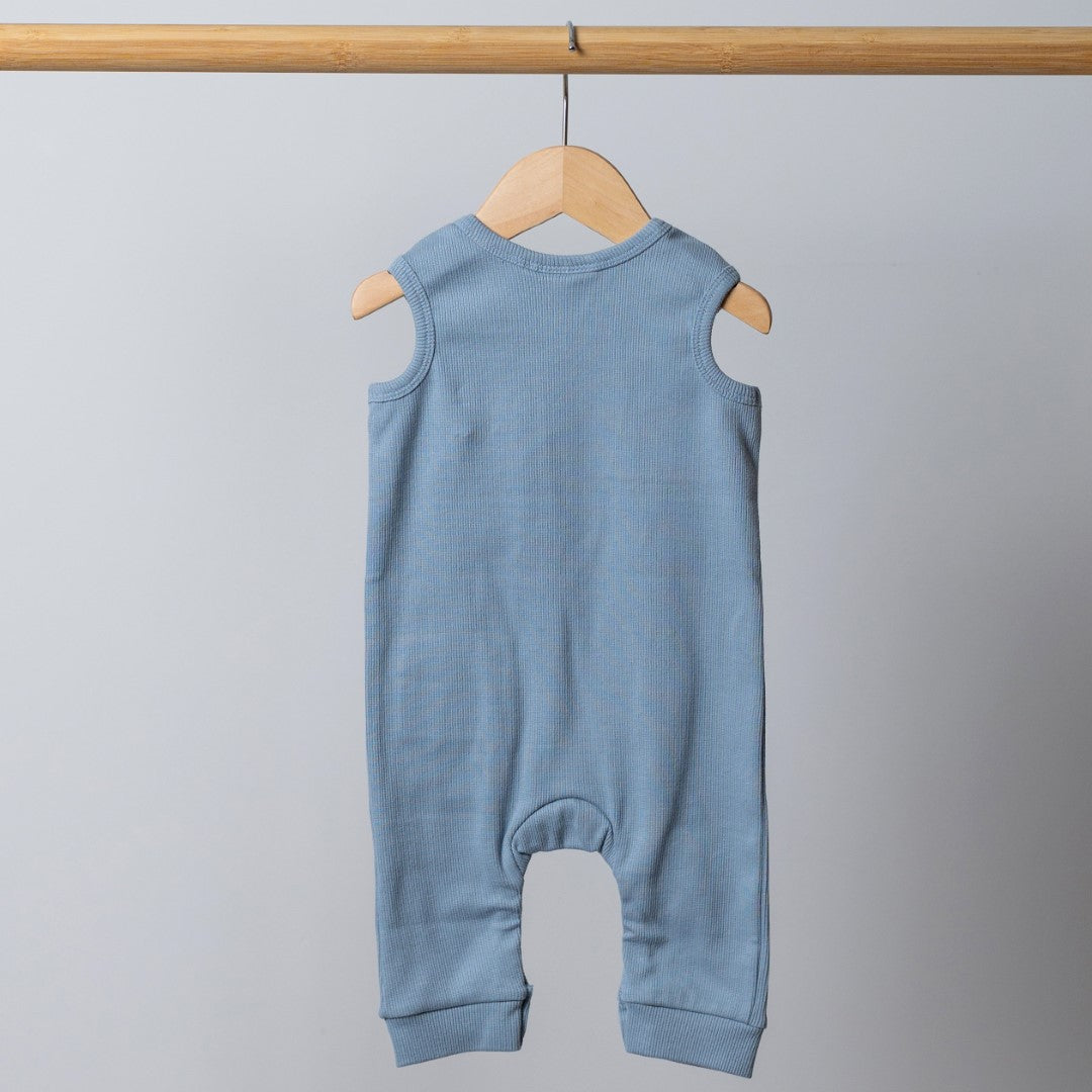 Slate blue sleeveless rib baby romper hanging on a wooden frame, back view. Neutral background.