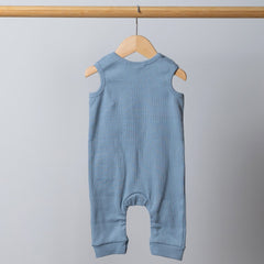 Slate blue sleeveless rib baby romper hanging on a wooden frame, back view. Neutral background.