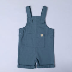 Flat lay of slate blue kids' cotton dungaree shorts, front view. The organic cotton fabric is soft and breathable, with a simple and timeless design.