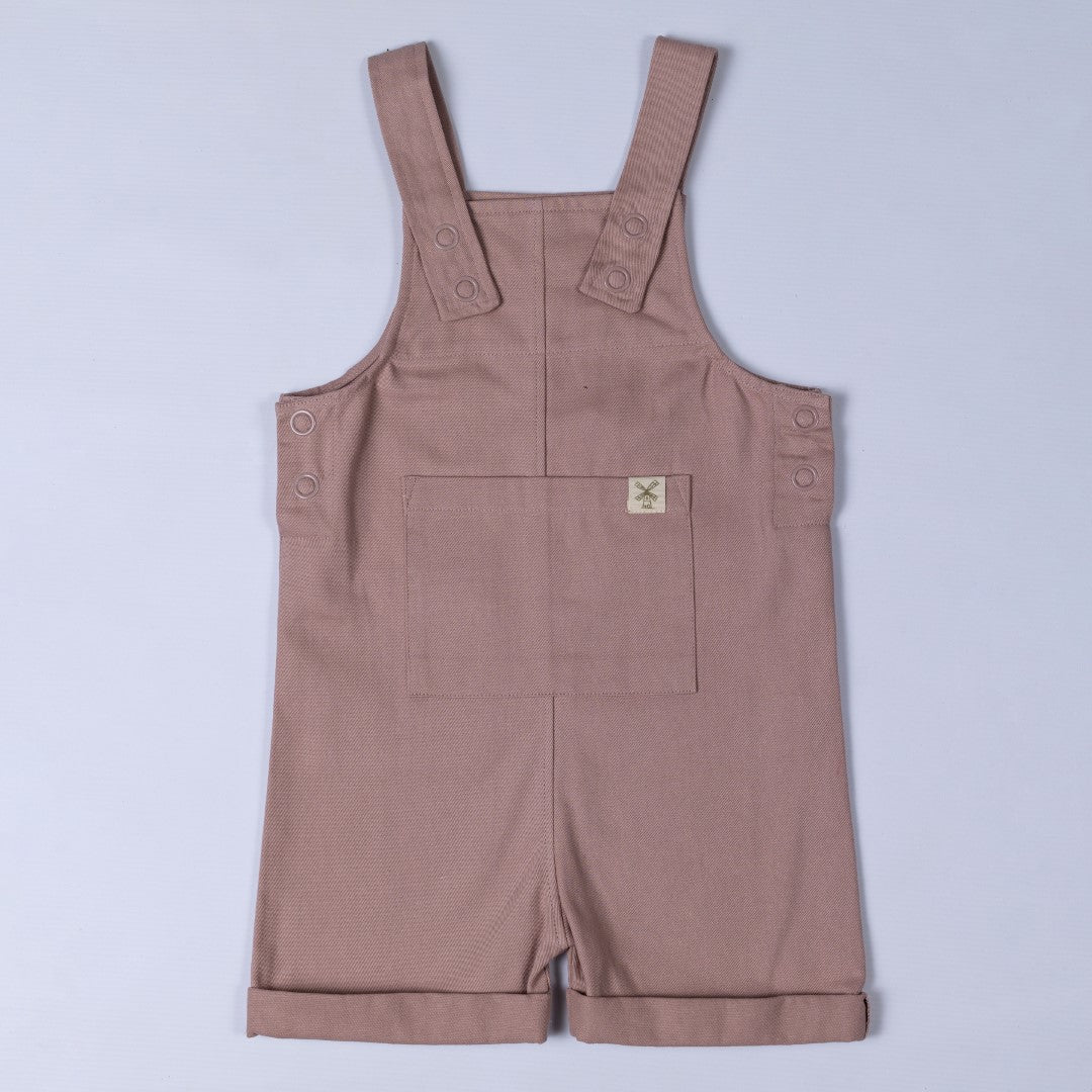 Flat lay of dusty pink kids' cotton dungaree shorts, front view. A soft pastel colour, designed with breathable organic cotton for comfortable everyday wear.