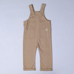 Front view of oat-coloured kids' dungarees with patch pockets, designed for comfort and style.