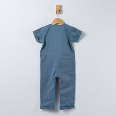 Back of slate blue short sleeve overall with patch pocket on right leg and rolled hem