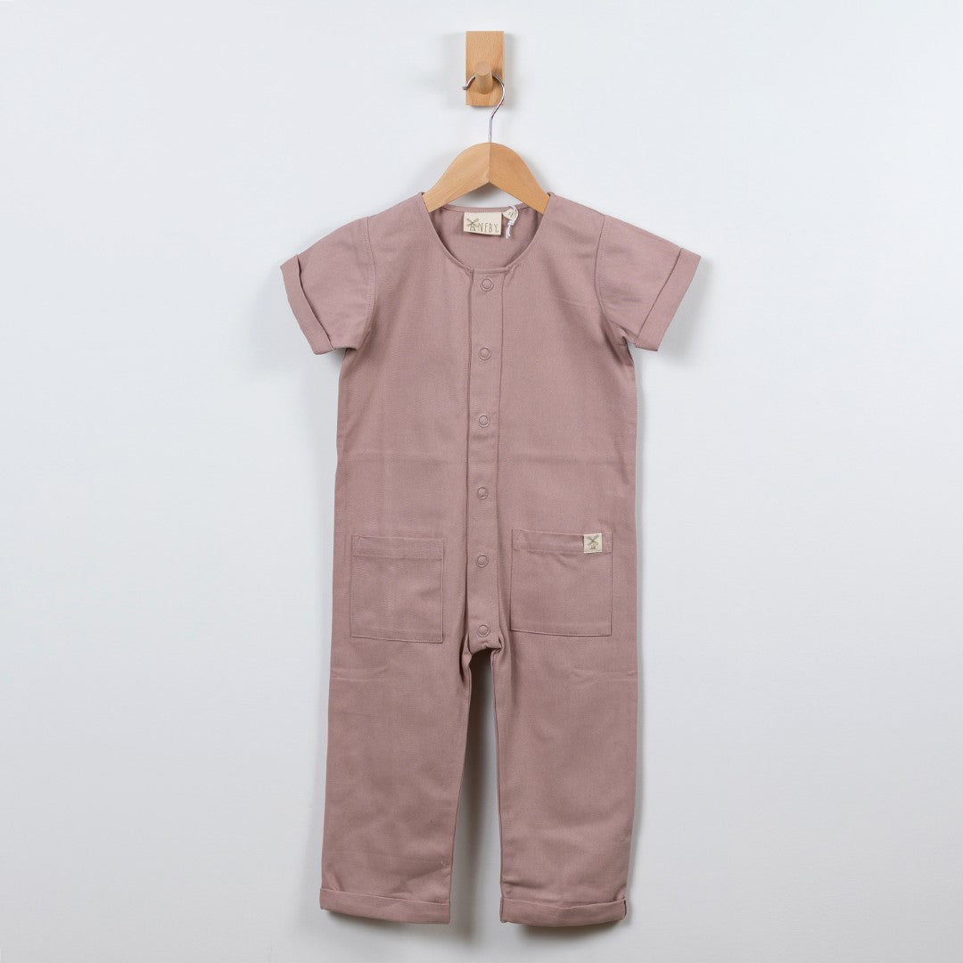 Dusty pink short-sleeve overall hanging on a wooden hanger with a front view in a neutral background.