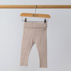 Organic oat ribbed baby leggings shown from the front, with the Aneby hem tag visible on the waistband. The soft ribbing and high-quality organic fabric are highlighted.