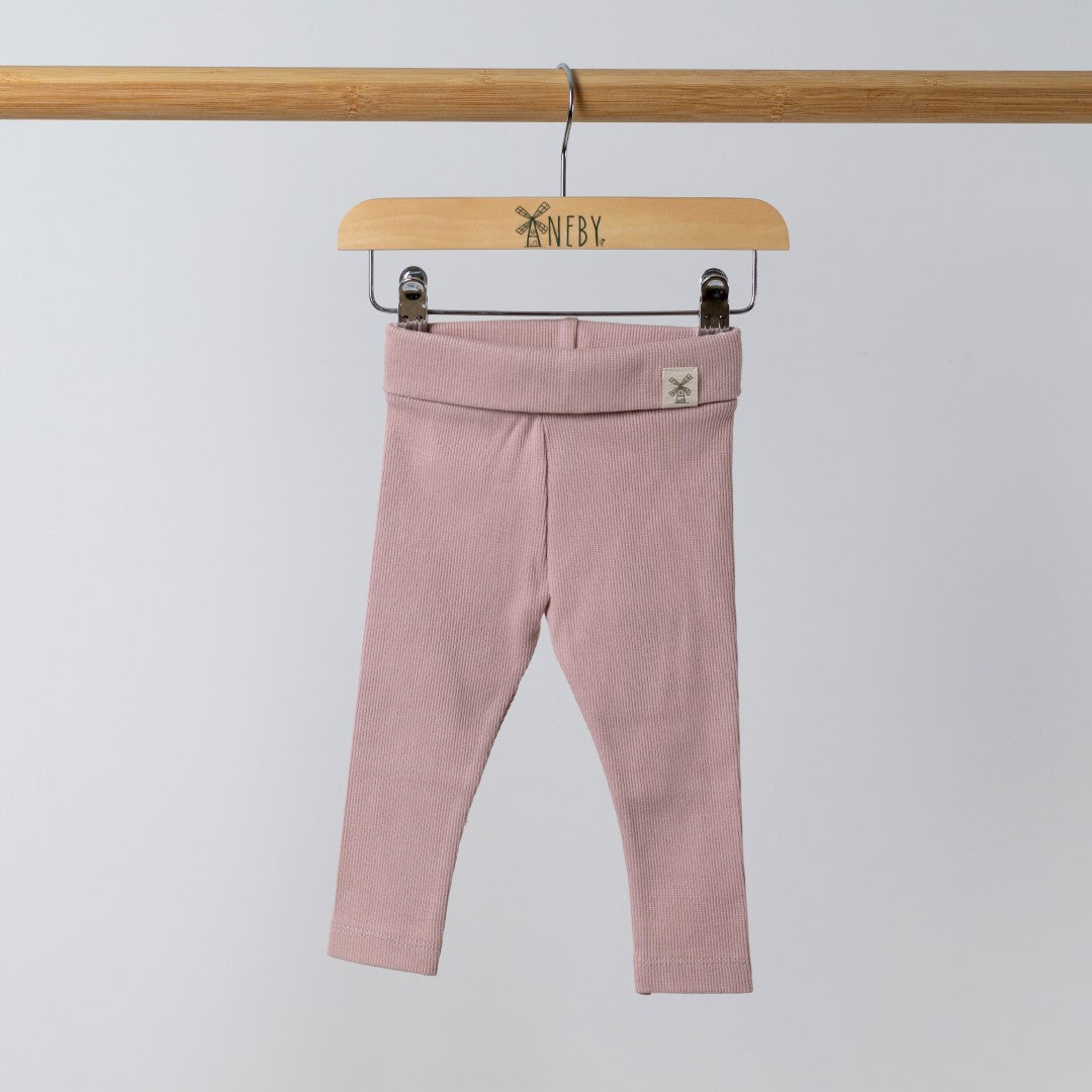 Front view of organic pink ribbed baby leggings with the Aneby hem tag visible on the waistband.