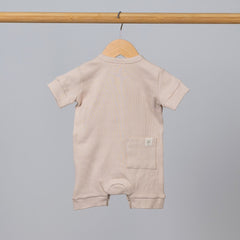 Oat short sleeve rib baby romper hanging, back view with pocket and Aneby hem tag visible.